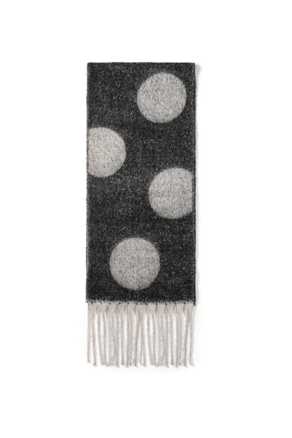 Detail van zwarte sjaal met grote lichte polka dots en franjes